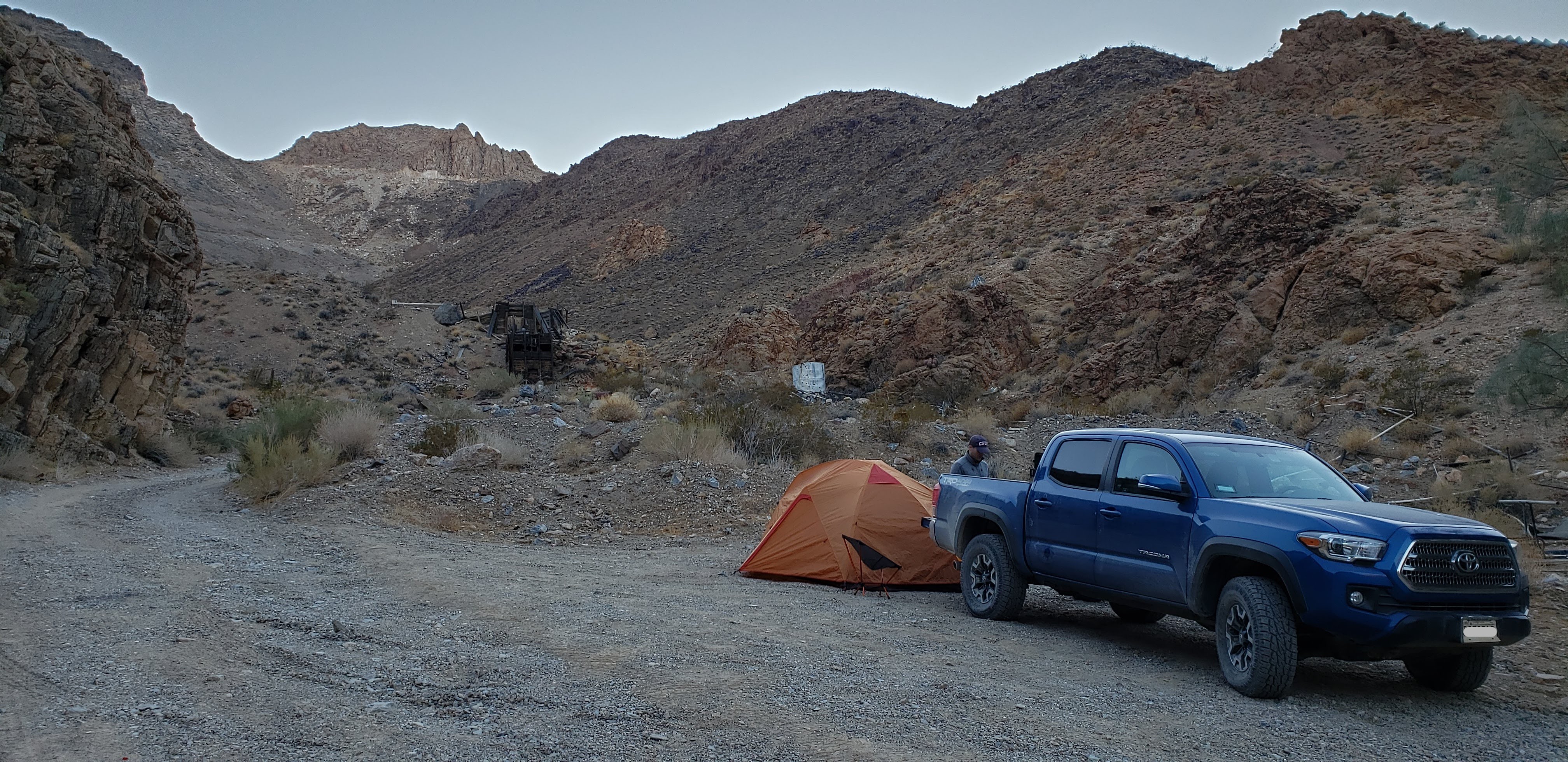 Blue Tacoma navigating a trail while wheels lift off the ground