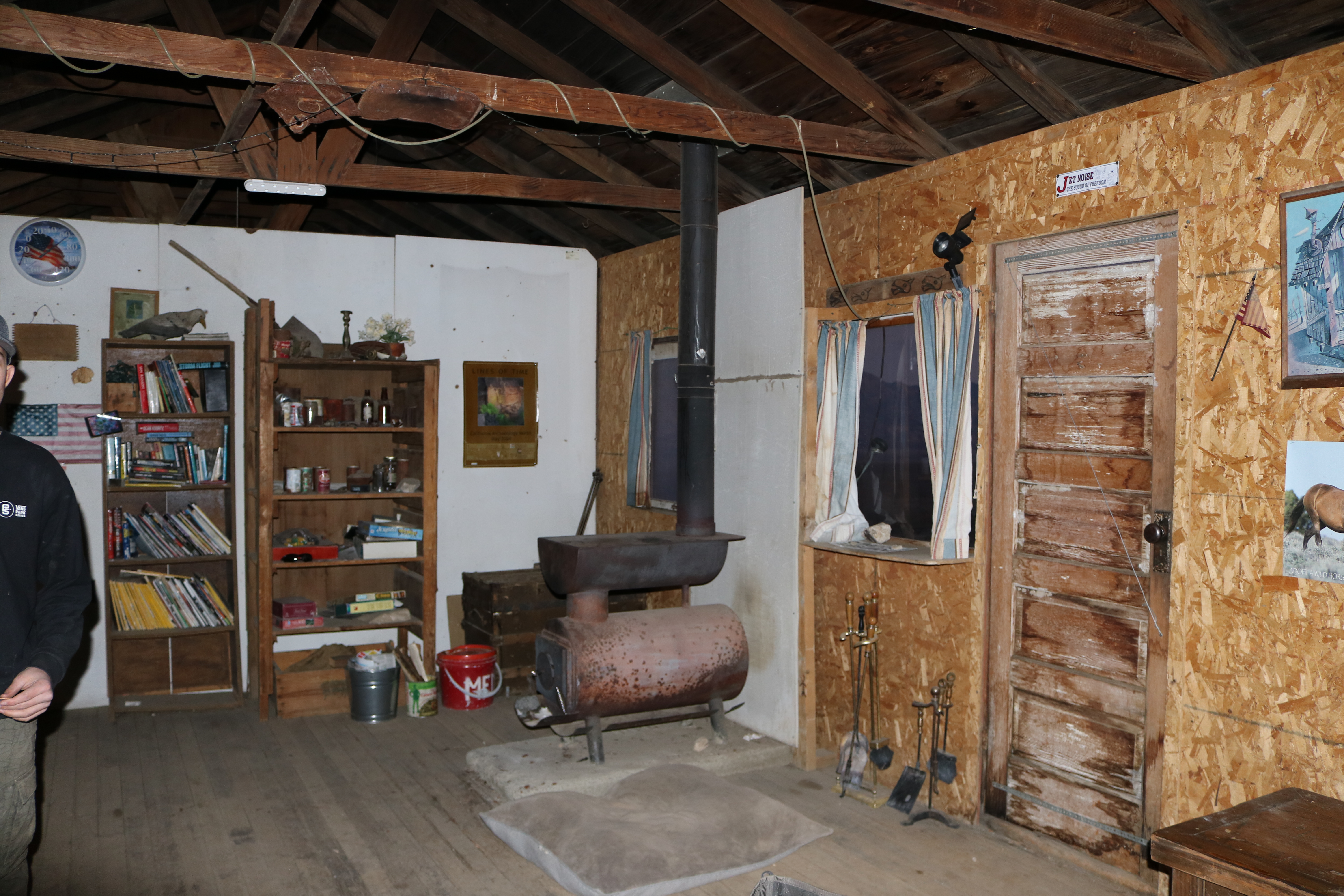 A rustic cabin interior with a wood burning stove.