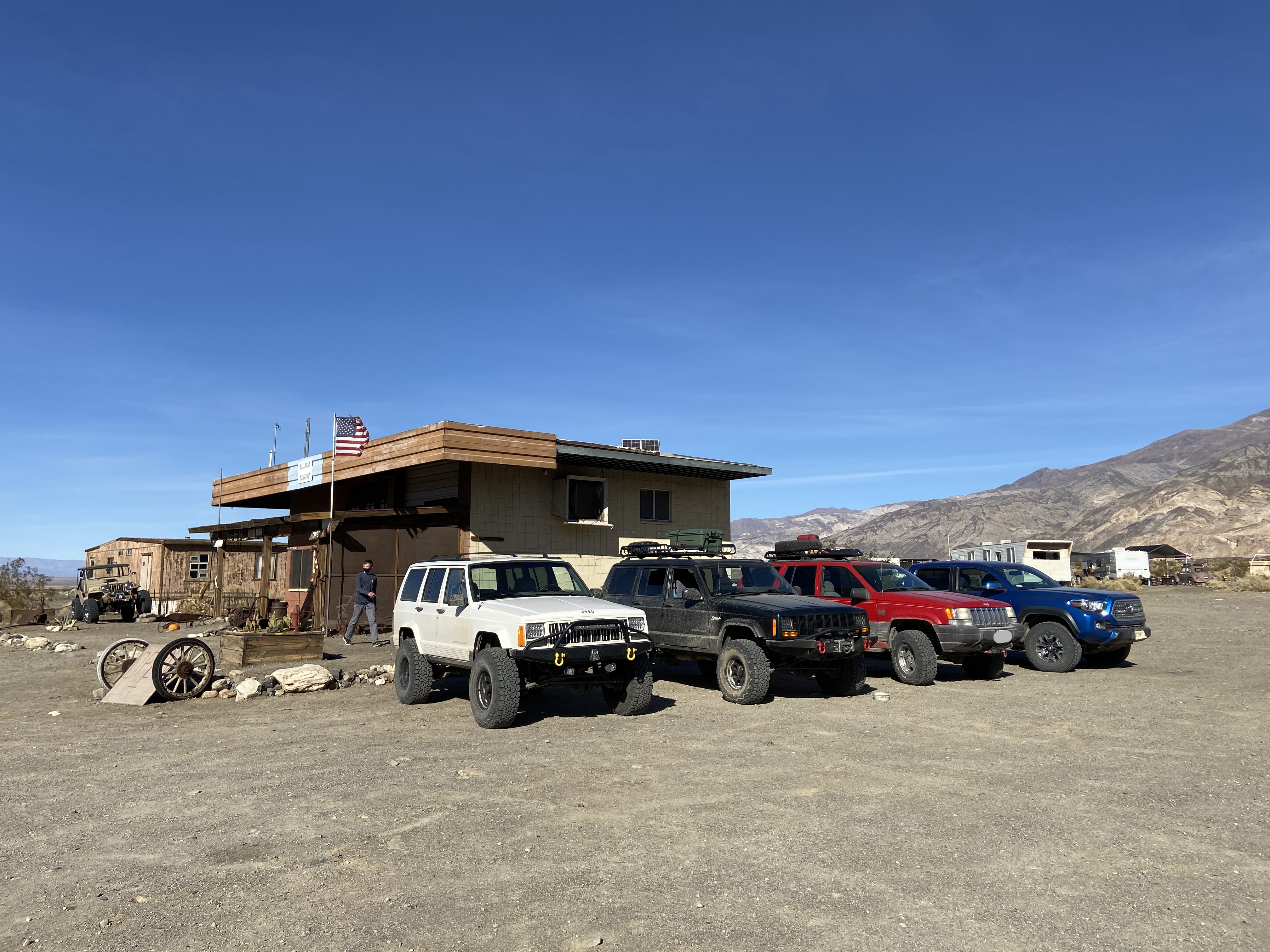 A white XJ, a green XJ, a red ZJ, and a blue Tacoma staged outside the Ballarat General Store.