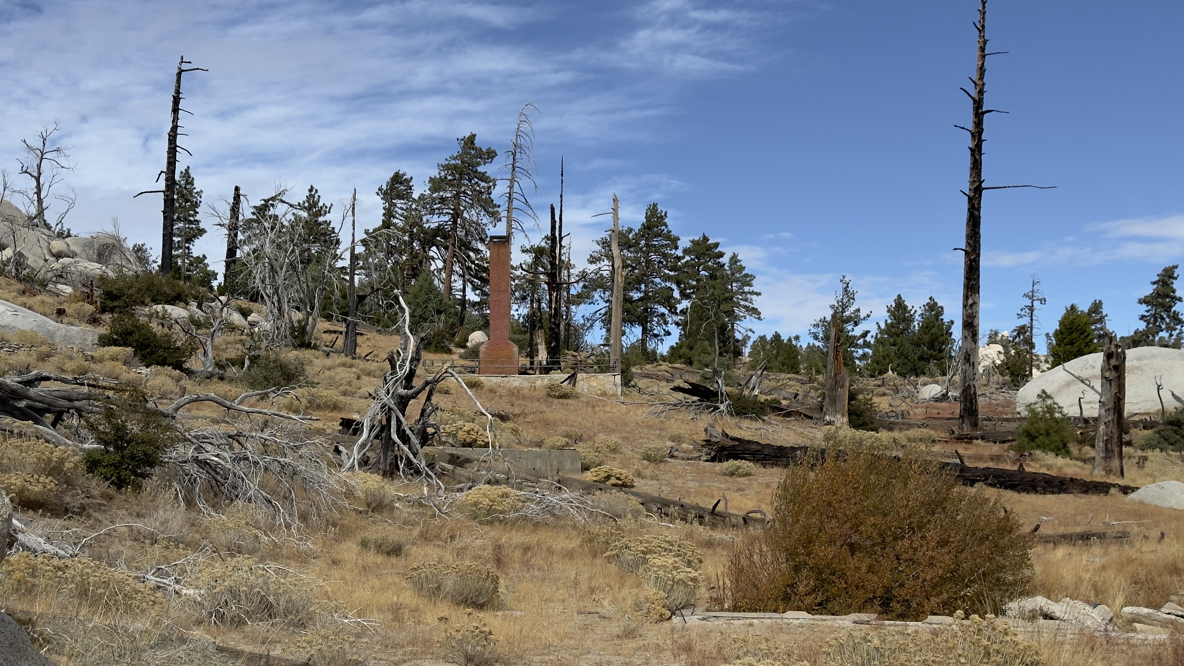 Mountainside landscape with a brick chimney standing oddly alone.